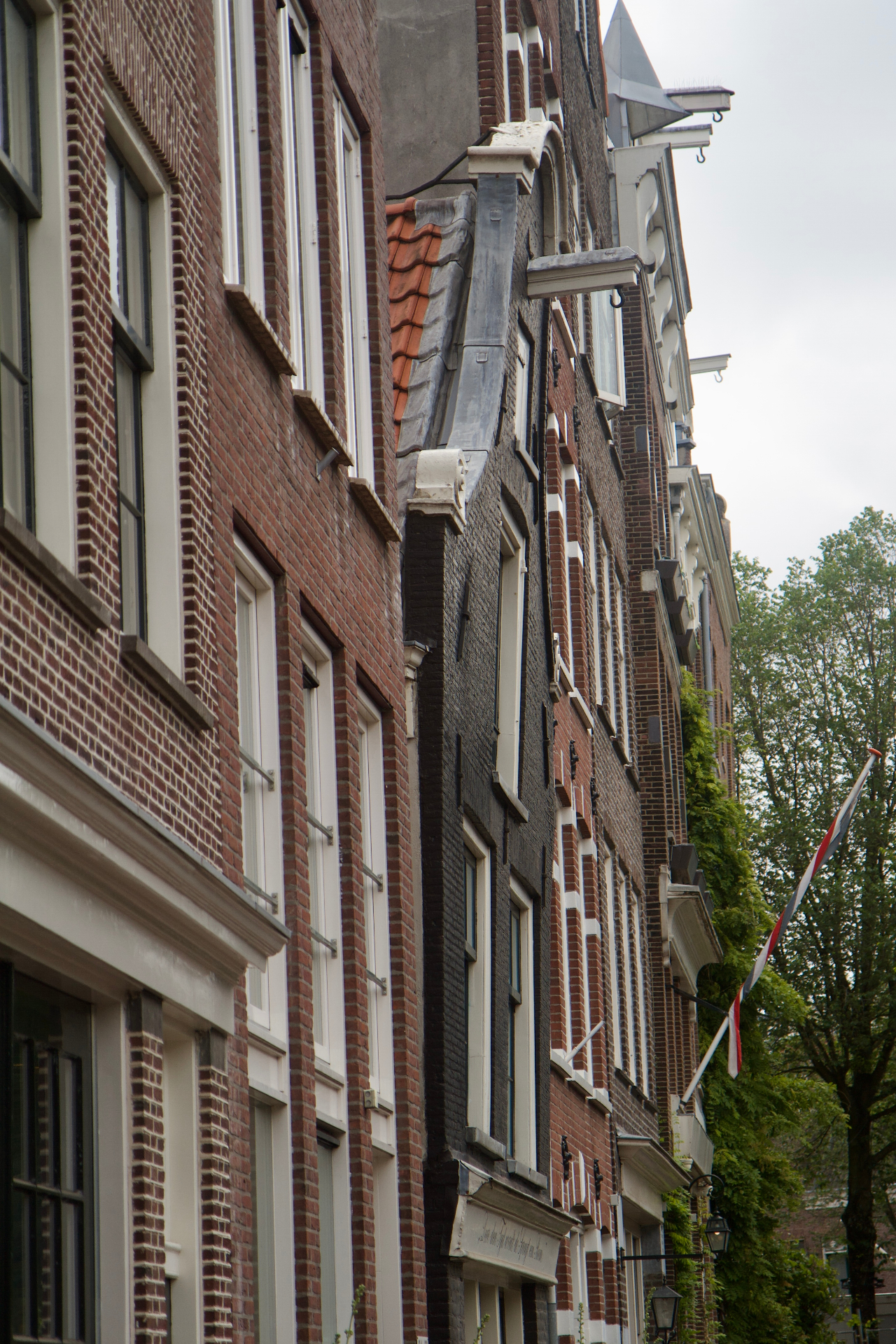 Schuine rij historische gevels langs een Amsterdamse straat
